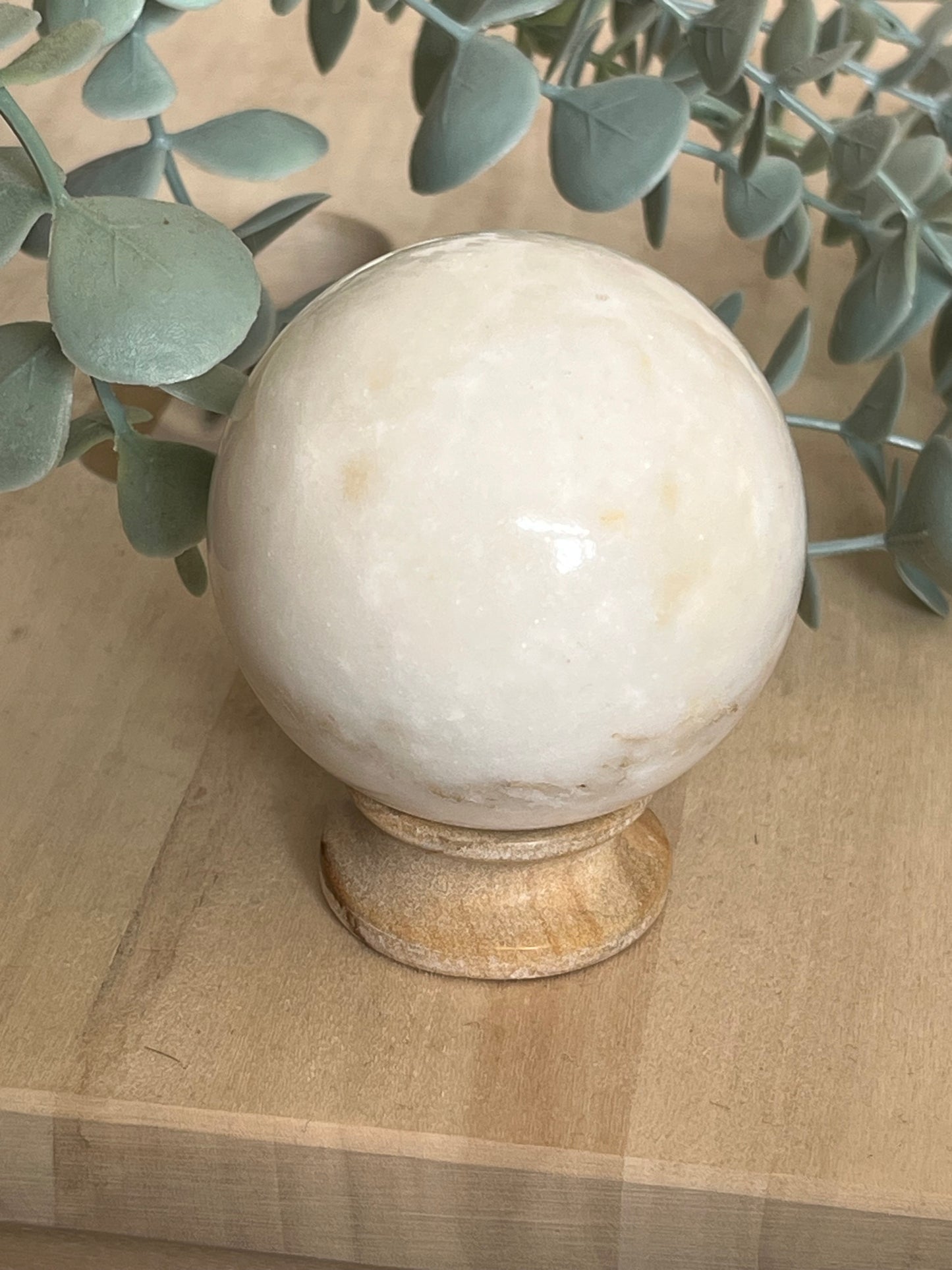 Witte maansteen bol als Japandi woondecoratie met rustgevende en natuurlijke uitstraling.