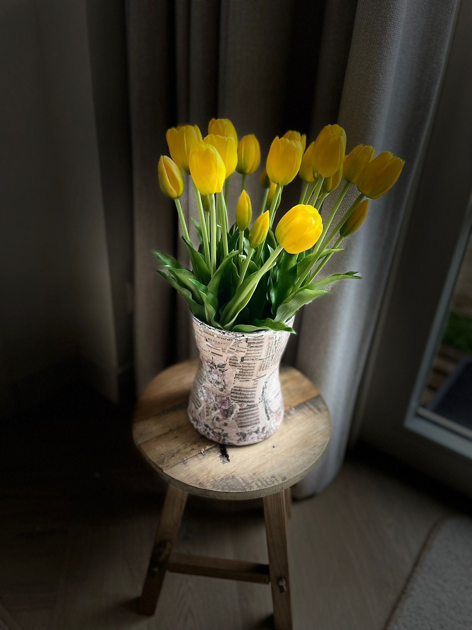 Gele kunst tulpen in vaas bij weinig licht – sfeervolle nep tulpen