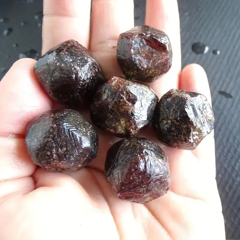 Hand met natuurlijke granaat edelstenen voor spirituele groei, balans en positieve energie.