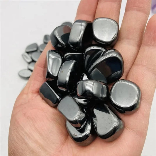 Hand met magnetische hematiet stenen voor energetische healing, focus en ontspanning.