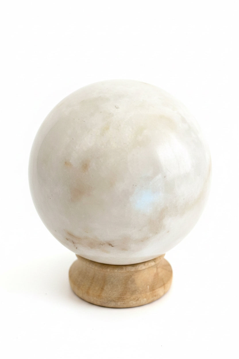 Close-up van een witte maansteen bol met natuurlijke glans en spirituele uitstraling.
