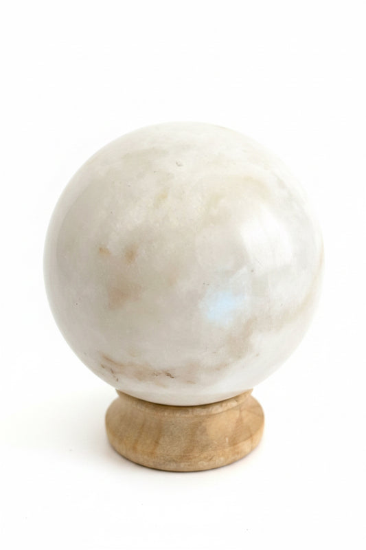 Close-up van een witte maansteen bol met natuurlijke glans en spirituele uitstraling.