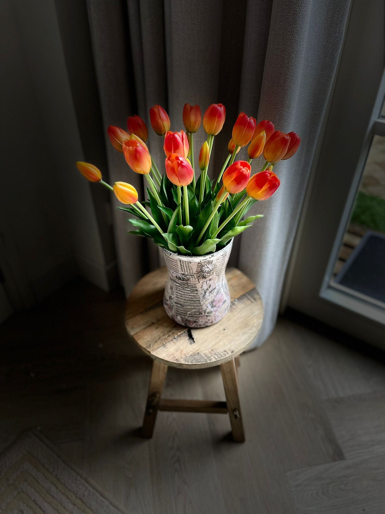 Oranje kunst tulpen in vaas bij weinig licht – sfeervolle nep tulpen